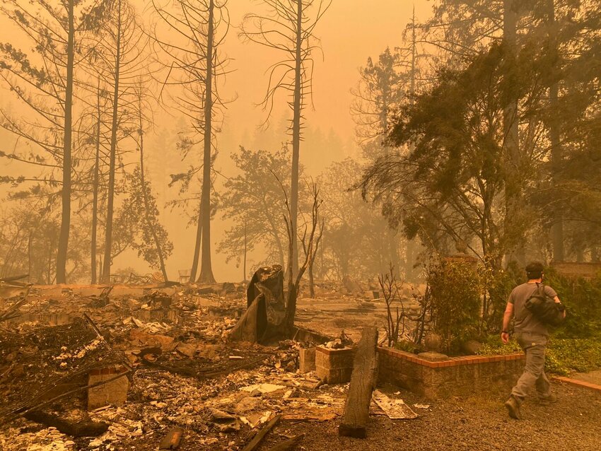 Sam Drevo walks by the burned foundation of his mother's home in Gates following the 2020 Labor Day fires. A proposal from Sen. Jeff Golden would create a climate superfund to help pay for wildfire prevention and response. (Photo courtesy of Tyler Westfall)