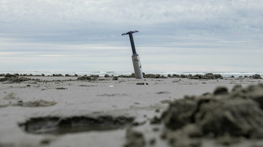 A clam gun is seen from behind a freshly dug hole during a razor clam dig at Grayland Beach on March 8, 2024.