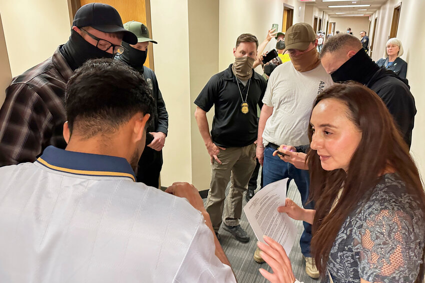 Immigration court volunteer Marjorie Miller gives guidance and support to a Colombian man who was about to be taken into custody by Immigration and Custom Enforcement officers in the hallway after his hearing with an immigration judge in Seattle, June 3, 2025.