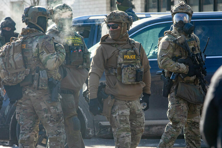 Federal agents in fatigues gather near the scene of 26th Street West and Nicollet Avenue, where federal agents shot and killed a 37-year-old man Saturday, Jan. 24, 2026, the third shooting in as many weeks. (Photo by Nicole Neri/Minnesota Reformer)