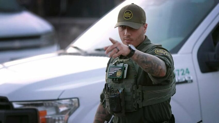 A U.S. Border Patrol agent gestures while pursuing crossers near Sunland Park, N.M., on July 17, 2024.