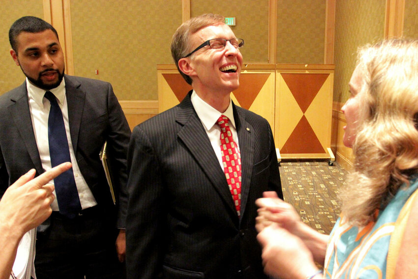 Washington state Republican gubernatorial candidate Rob McKenna speaks to an audience member at the Rotary Club of Seattle forum., Wednesday, June 27, 2012. McKenna and Democratic candidate Jay Inslee were asked questions at the forum about the state's budget, health care and other issues. (AP Photo/Manuel Valdes)