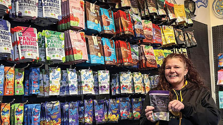 Joy Smith, general manager of the newly reopened 20After4 dispensary in Woodland, stands in front of a wall of edibles including hard candies, gummies and chocolates made with THC and cannabis extracts. She said the dispensary at 1511 N. Goerig St. has a particularly large selection of candies with different flavors, textures and potencies.