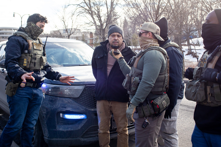 ICE agents allow a driver to talk to his wife as they arrest him and his passenger during a traffic stop on Feb. 11, 2026 in Minnesota. (Photo by Nicole Neri/Minnesota Reformer)