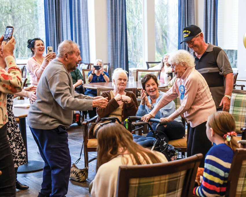 Kuky Nutter, right, with ribbon, dances with family and friends during her 103rd birthday celebration on Saturday, March 7, at Mallard Landing Assisted Living.