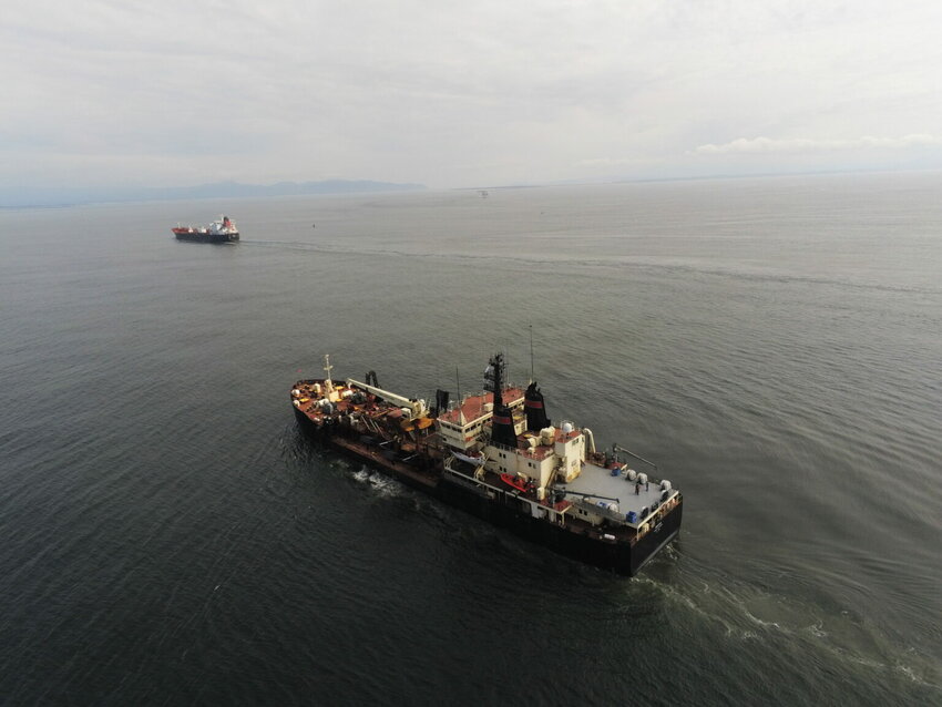 Two dredging vessels, the government-owned Essayons and the Bayport, a contract vessel, at the mount of the Columbia River.