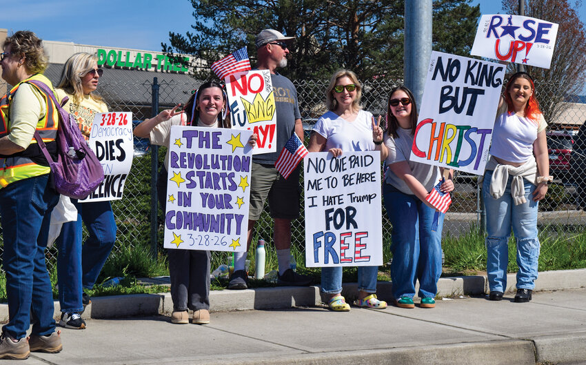 Protesters hold signs south of the Safeway parking lot along Main Street on March 28. The demonstration marked Battle Ground&rsquo;s second &ldquo;No Kings&rdquo; protest, part of a growing national movement opposing President Donald Trump&rsquo;s agenda.