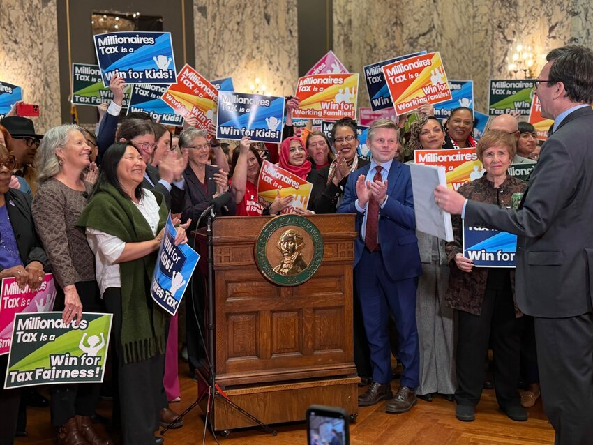 Supporters of Washington&rsquo;s new income tax on millionaires celebrate as Gov. Bob Ferguson prepares to sign it on Monday, March 30, 2026, in Olympia. (Photo by Aspen Ford/Washington State Standard)