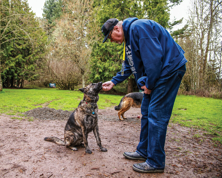 Mark Shanholtzer, DOGPAW vice president of park operations and administration, feeds his dog Neo a treat at Kane Memorial Dog Park in the Hockinson Meadows Community Park on Thursday, April 2.