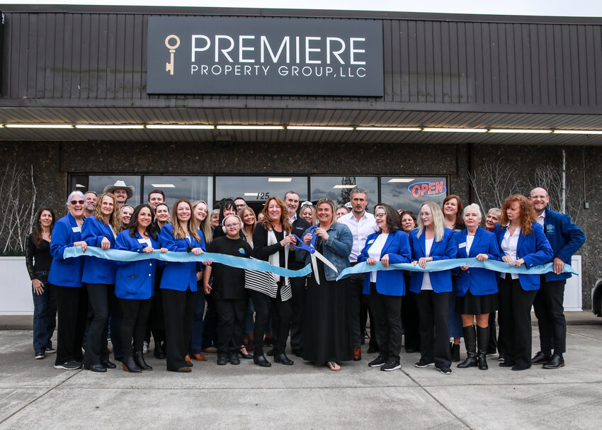 Shannon Wyman, left center with scissors, and Lindsey Maze, right center with scissors, cut the ribbon celebrating a new chapter as Legions Realty merged with the Premiere Property Group LLC on Tuesday, March 31.