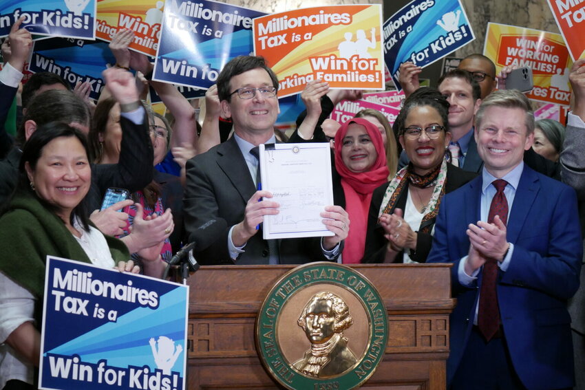 Supporters of Washington&rsquo;s new income tax on millionaires celebrate after Gov. Bob Ferguson signs the bill into law on Monday March 30, 2026. (Aspen Ford/Washington State Standard)