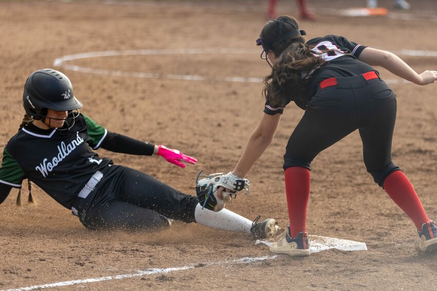 Woodland&rsquo;s Jolie Oathes (8) swipes third just ahead of the tag from R.A. Long&rsquo;s Zoey Jason (20) during a 2A GSHL softball game on Thursday, April 16, in Woodland. That extra base was part of an aggressive approach that kept the Jills&rsquo; defense on edge all game as the hometown Beavers went on to win 13-3.