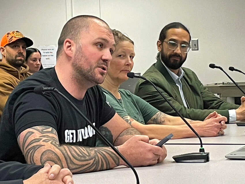 Cory Maxwell of Kitsap County (left) called on some members of the Washington Fish and Wildlife Commission to step down in public comments on April 17, 2026. Rachel Bjork and Francisco Santiago-Avila look on. (Photo by Jerry Cornfield/ Washington State Standard)