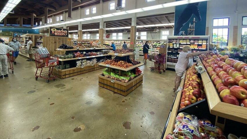 A grocery store produce section with apples, peaches and other fresh items.