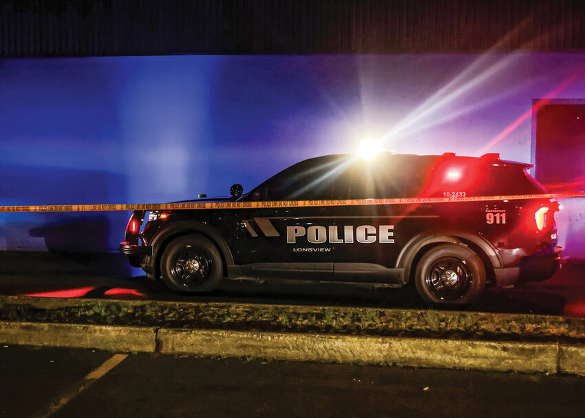 A Longview Police Department patrol vehicle sits behind crime scene tape just before midnight on Saturday, April 11, at the scene of a shooting that left two dead during an event attended by around 200 people at the AWPPW Hall in the 700 block of 15th Avenue.