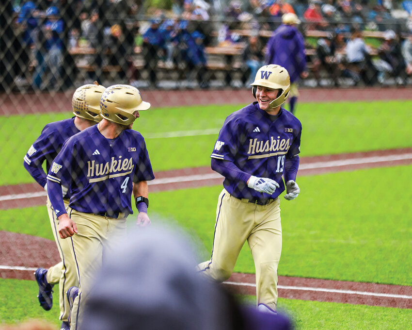 University of Washington leadoff batter and Battle Ground High School graduate Jackson Hotchkiss, right, celebrates after hitting a three-run home run against the University of Portland during the NWBCA College Classic at the Ridgefield Outdoor Recreation Complex on Tuesday, April 21.