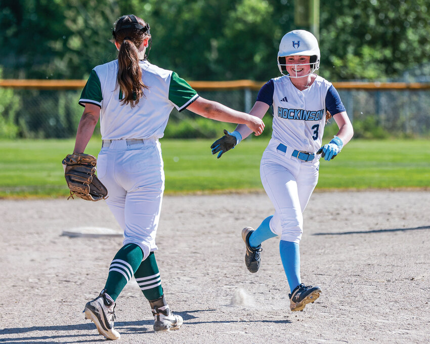 Hockinson&rsquo;s Lily Ritton, right, is high-fived by Woodland shortstop Emma Barrow after Ritton&rsquo;s home run in the first inning of Woodland&rsquo;s 11-9 win on Monday, May 4.