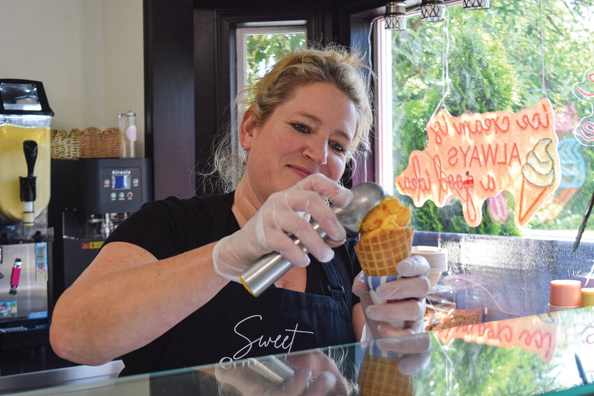 Tracy Coiteux, owner of The Sweet Collective in downtown La Center, serves mango sorbet in a waffle cone. The dessert and coffee shop, which opened in April at 103 E. Fourth St., offers local ice cream, baked goods and drinks.