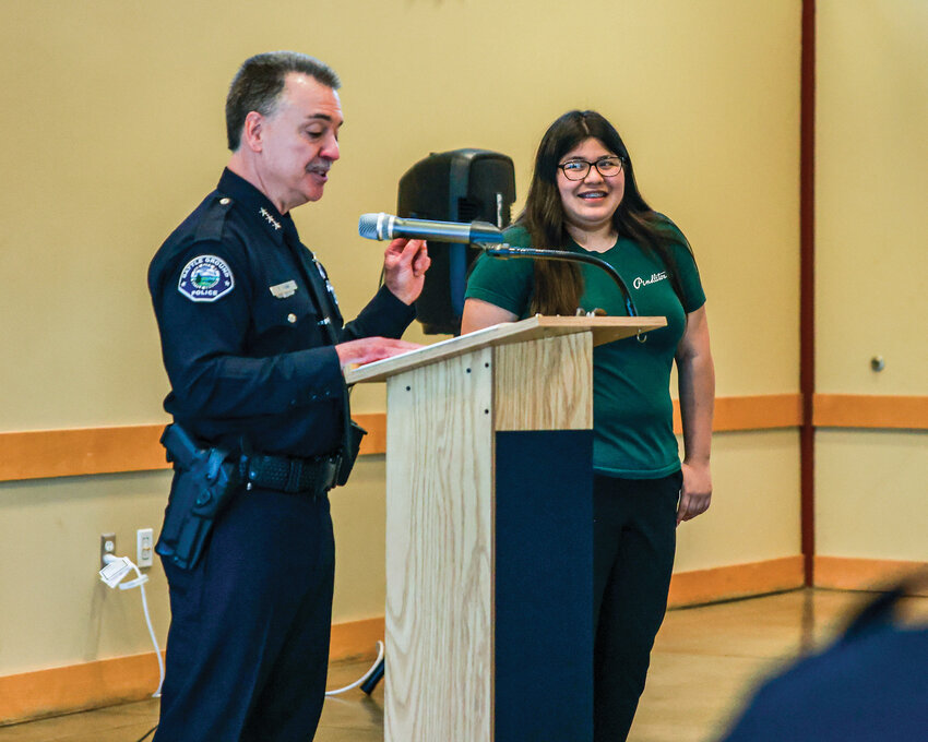Nathalie Pineda-Mancia, right, smiles while Battle Ground Police Chief Dennis Flynn talks about her stopping a home intruder during the Battle Ground Police Department awards ceremony on Wednesday, May 20.