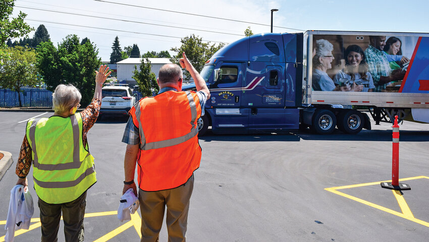 A truck driver with The Church of Jesus Christ of Latter-day Saints waves back at volunteers while leaving the Clark County Food Bank after delivering 40,000 pounds of food Thursday, May 28. The donation is expected to help feed about 1,400 families for one week in Clark County.
