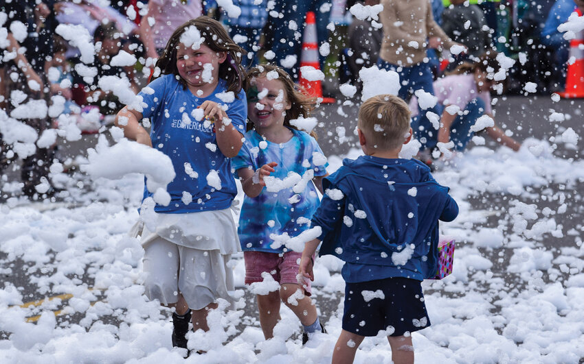 Children run past as bubbles drift across the parade route as Parties Inc.&rsquo;s truck passes by during the 2026 Hockinson Fun Days Parade on Saturday, May 30. The parade, one of several community events held during Hockinson Fun Days, drew thousands last weekend.
