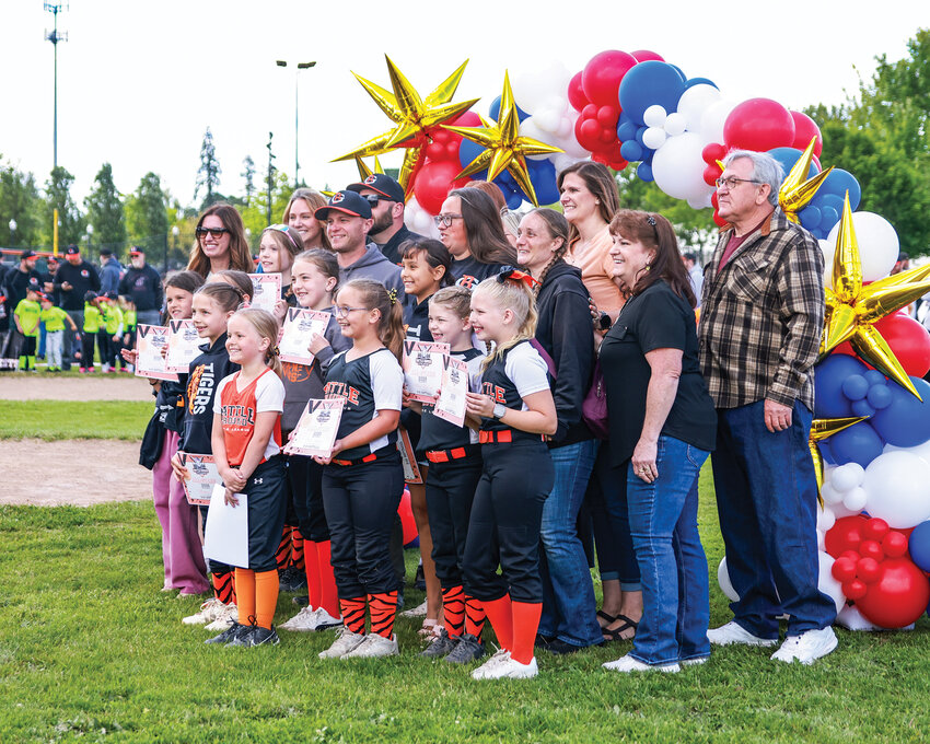 Members of Battle Ground Little League's 1996 Washington state champion minors softball team pose with current Battle Ground Little League all-star softball players during the league's closing ceremonies on Saturday, May 30. The championship team was honored 30 years after becoming the first Battle Ground Little League softball team to win a state title.