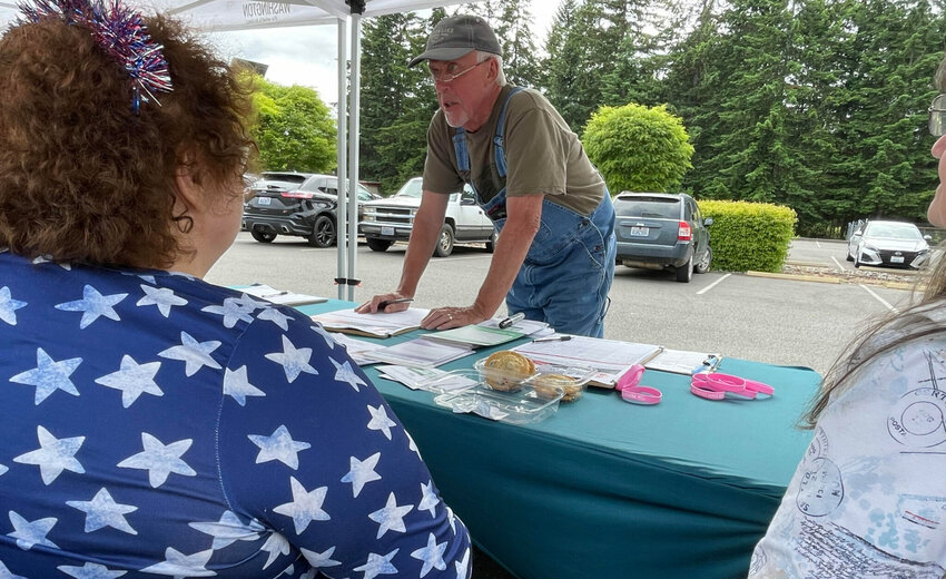 Doug Hicks signs a initiative petition on June 3, 2026 in Tumwater, Washington. The proposed ballot measure would repeal a statewide income tax on high earners enacted earlier this year.