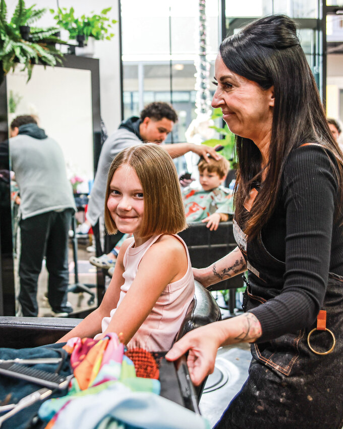 Parlour &lsquo;73 owner Andrea Mills, right, provides a free haircut for a young foster child during an event for foster children hosted in partnership with Cloth and Foster on Saturday, May 30, at the salon in the Battle Ground Village. The event provided complimentary haircuts, hair care items and support for foster families throughout Southwest Washington.