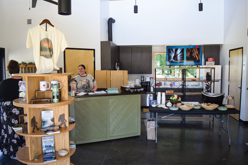 Apparel displays, informational materials and a slideshow featuring regional attractions are seen inside the Downtown Woodland Revitalization Welcome Center while employee Dakotah Lund works behind the front desk during the facility's Monday, June 1, soft opening.