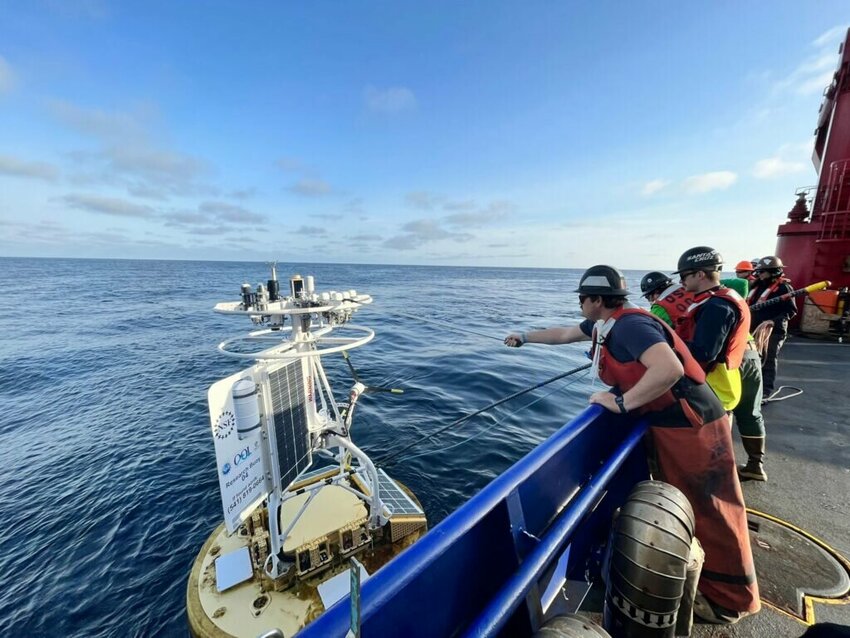 Oregon State University researchers maintain some of the Ocean Observatories Initiatives sensors along the Pacific Coast. In this photo, OSU researchers recover a buoy that measures ocean health. (Photo by Ocean Observatories Initiative)