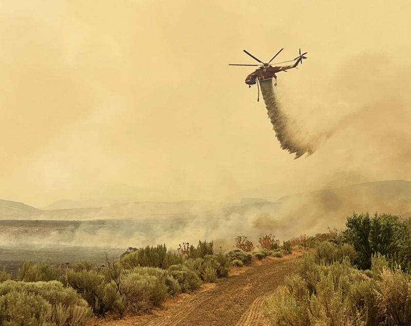 A helicopter drops flame retardant on the Cow Valley Fire in eastern Oregon on July 12, 2024. Scientists expect wildfires to continue to intensify with climate change.