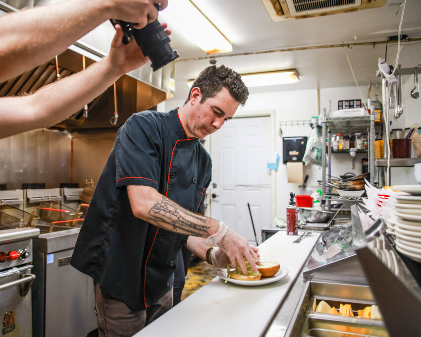 Sportsman&rsquo;s Public House Head Chef and Kitchen Manager Dakota Karsten prepares a burger on Friday, June 19, as the historic Ridgefield restaurant was being filmed by America&rsquo;s Best Restaurants for a feature hitting social media later this year.