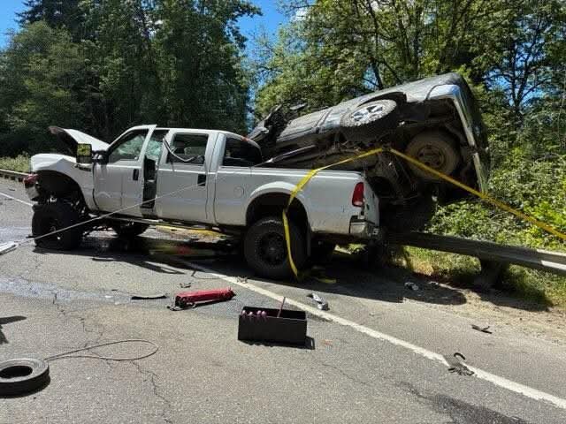 A heavily damaged pickup truck rests against a guardrail with another vehicle on top of it after a three-vehicle crash near the intersection of Northeast Lewisville Highway (state Route 503) and Northeast McBride Road between Fargher Lake and Battle Ground on Tuesday, June 16.