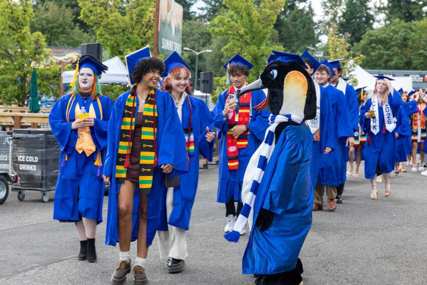 Clark College Mascot Oswald walks with grads at the commencement ceremony Thursday, June 18.