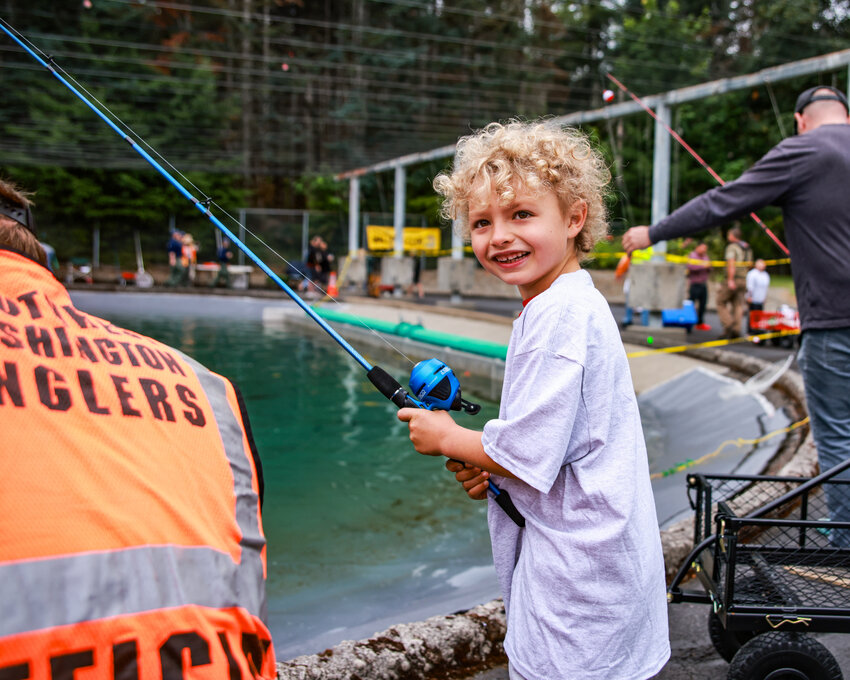 Remi, of Woodland, reels in a big rainbow trout during the 26th annual Merwin Day of Fishing for kids with disabilities on Saturday, July 11.