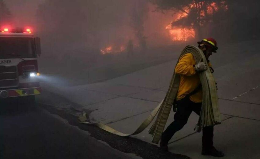 Firefighters fight to save homes from the Old Trails fire as it spreads into neighborhoods off of Indian Trail on Saturday in Spokane. It has burned at least 640 structures.