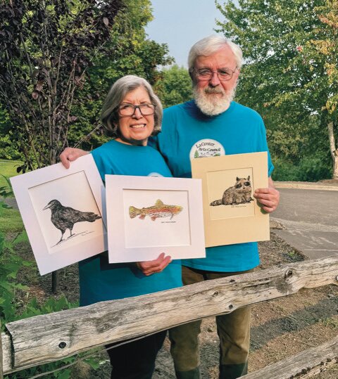 Founding La Center Arts Council member Daniel Masterson and his wife, Christina, with three pieces of Daniel&rsquo;s artwork that was on display at a recent council meeting.