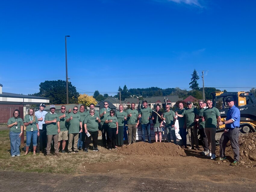 District and school staff, as well as local business owners and supporters, gather in front of the new construction trades building site.