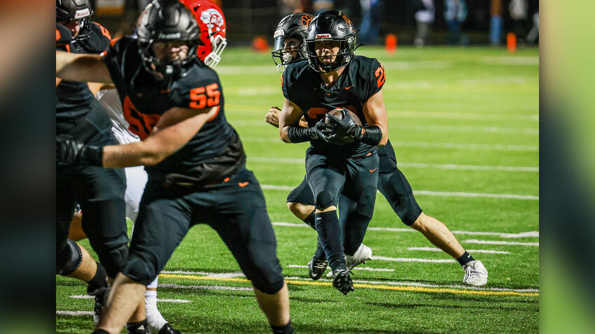 Battle Ground junior running back Miles Skov tries to shake off two diving Papermaker tacklers during the Tigers&rsquo; 42-25 loss to Camas on Friday, Oct. 2.