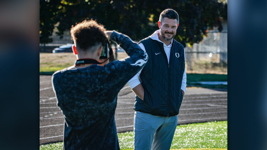 Oregon Ducks football head coach Dan Lanning stands with students who recognized him for photos at District Stadium in Battle Ground on Friday, Oct. 2.